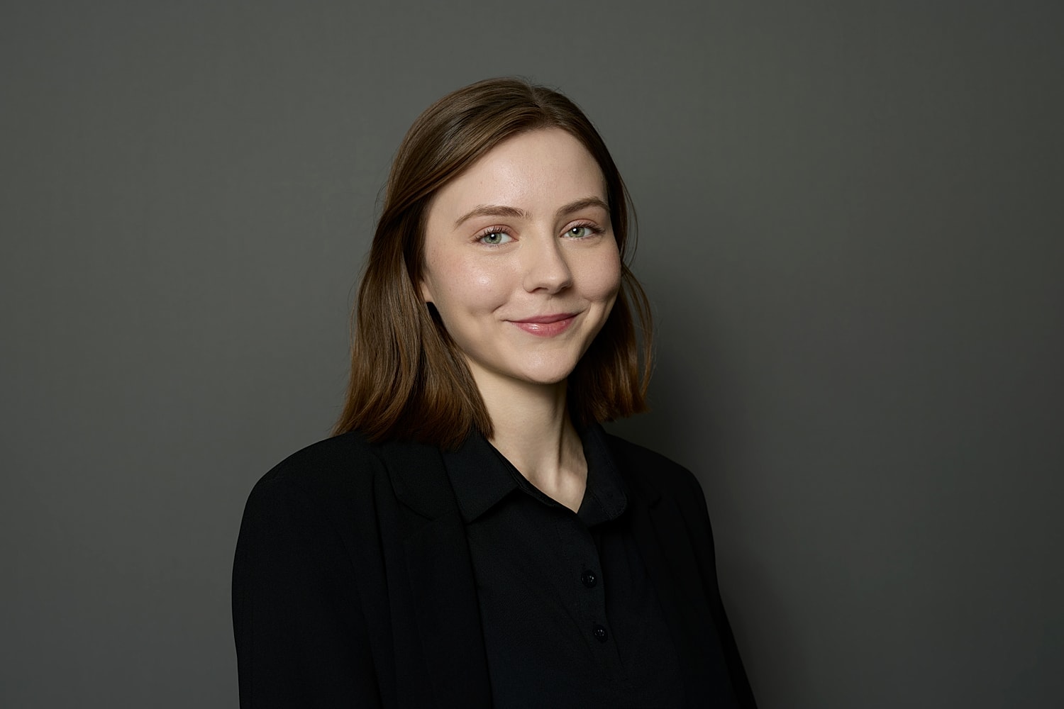 Professional woman smiling against gray background