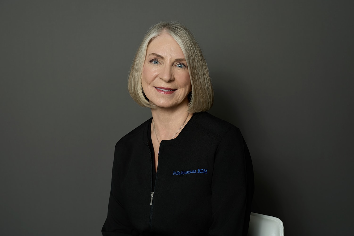 Portrait of a smiling professional in black attire.