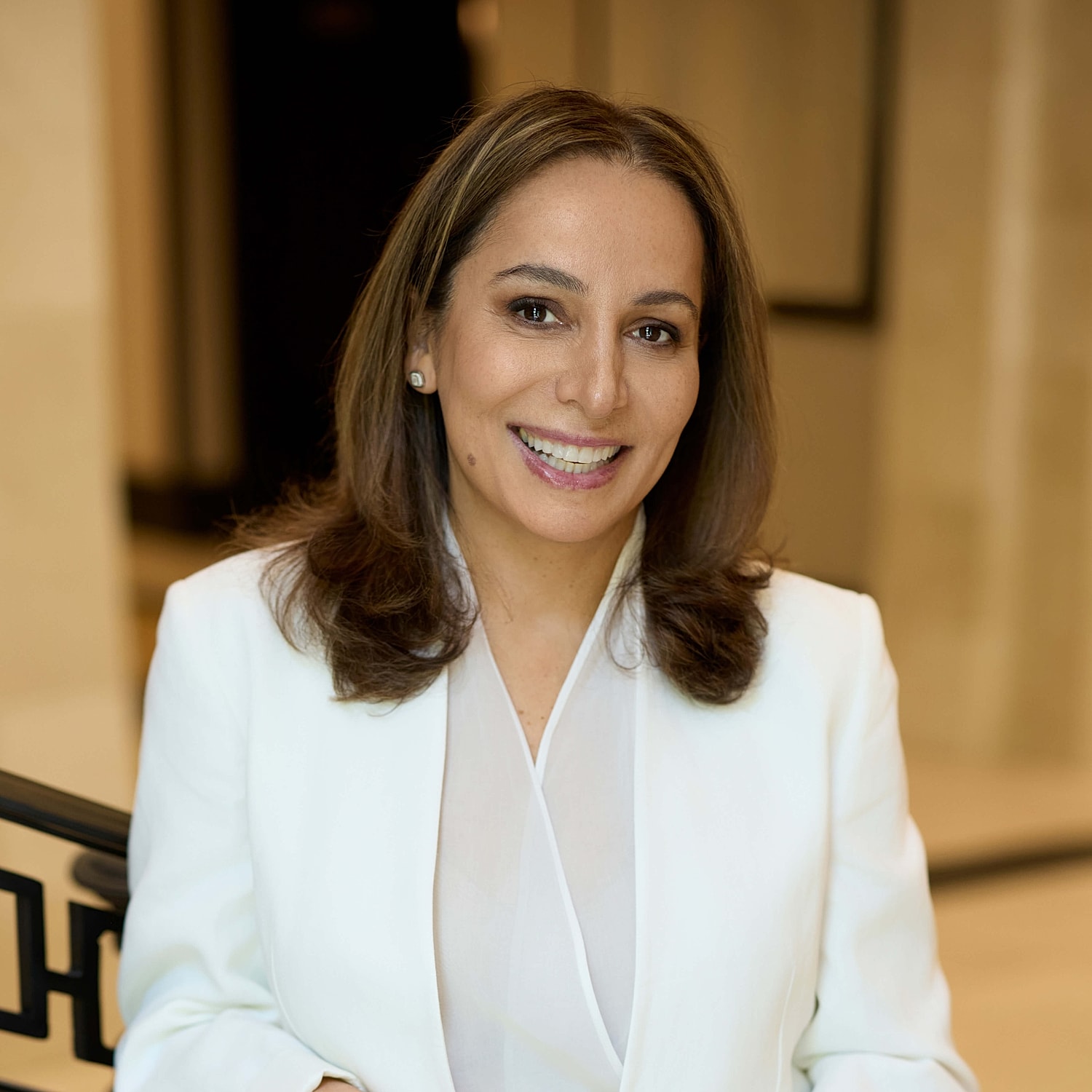 Smiling woman in a white blazer.