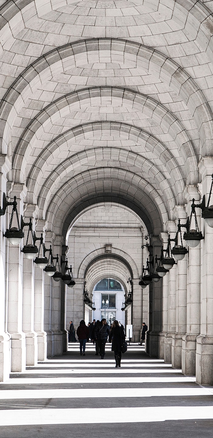 Architectural arches with people walking through.
